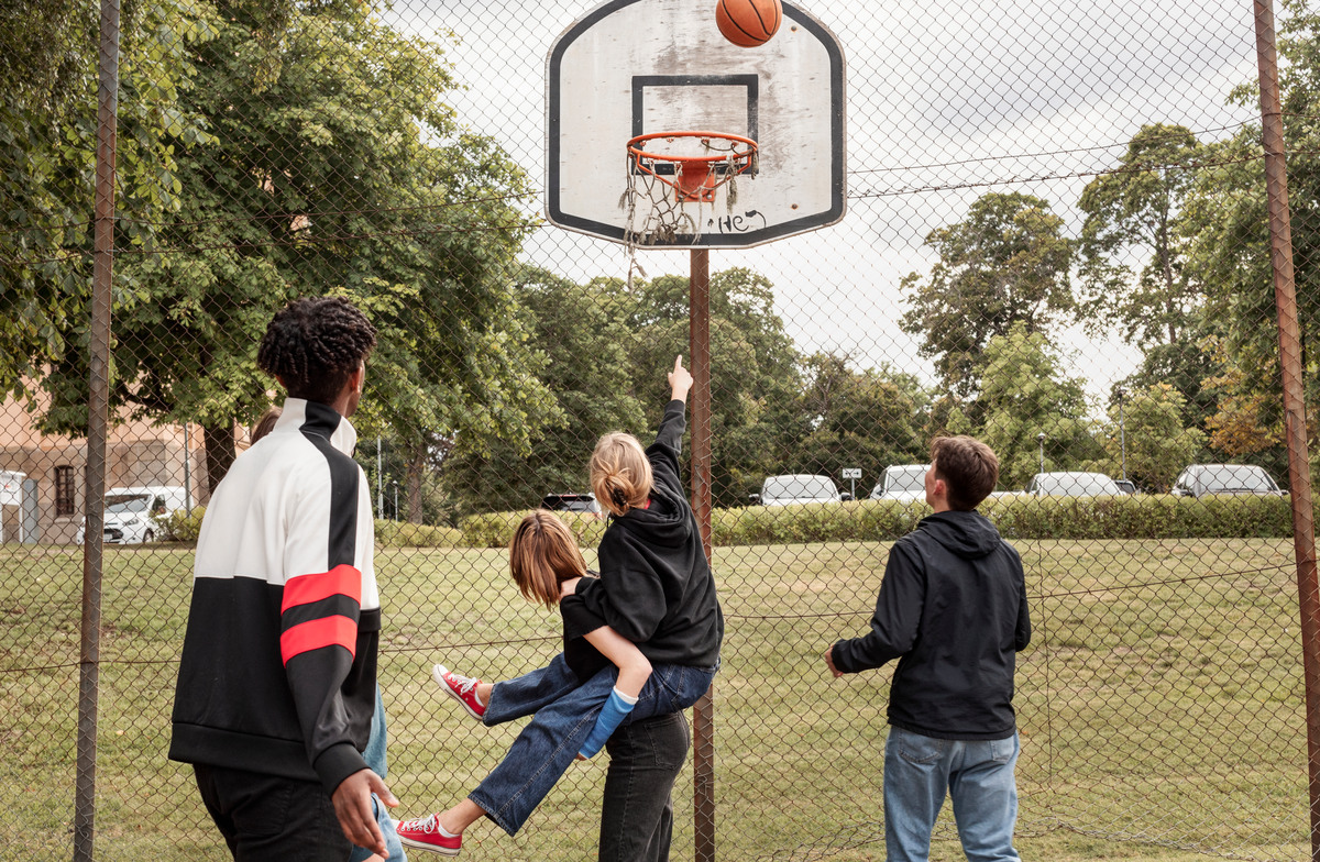 Ungdomar spelar basket i park