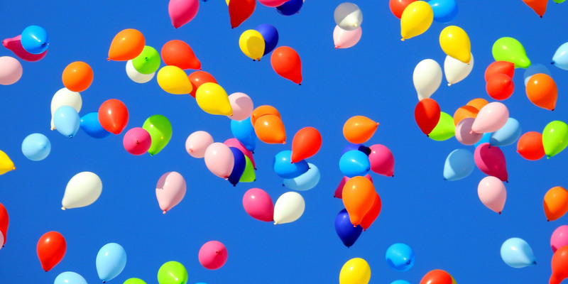 Blå himmel full med färgglada ballonger