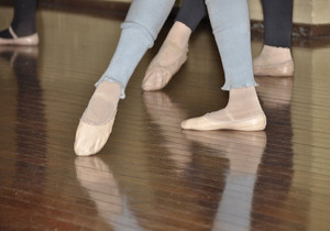 Ungdom har balettskor på fötterna och står i en dansposition.