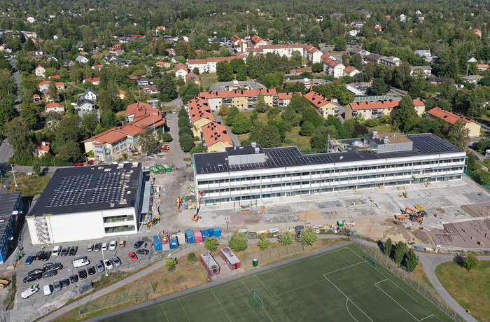 Pågående bygge av Fornuddens nya skola sett från Fornuddsparken. Sporthall till vänster och långsträckt skolbyggnad i tre våningar till höger.  