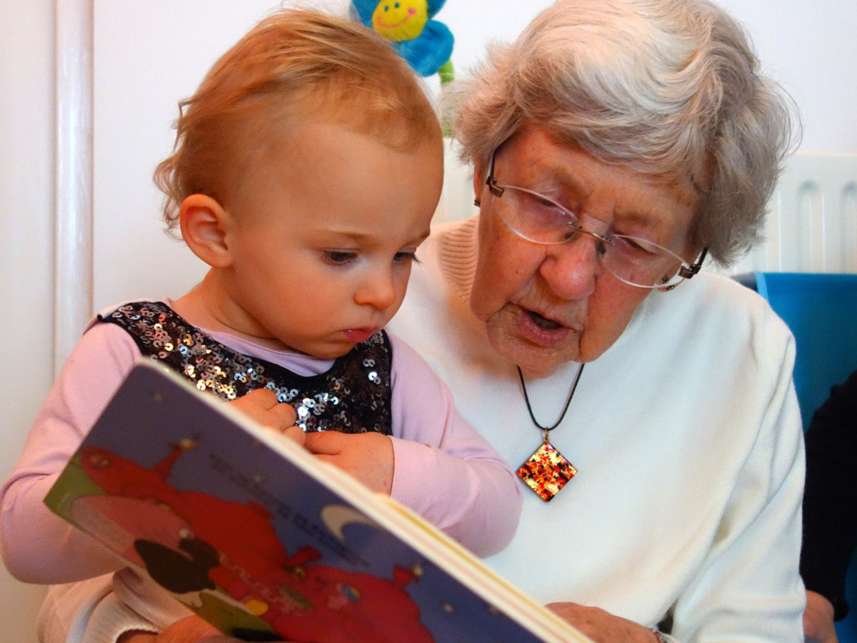 Äldre och barn läser bok