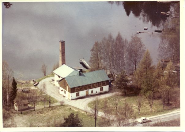 Flygbild över f d Ringströms tvätt i Hanviksviken, en industribyggnad med hög skorsten.