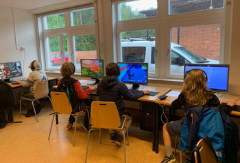 Elever sitter vid datorer under ett e-sportevent.