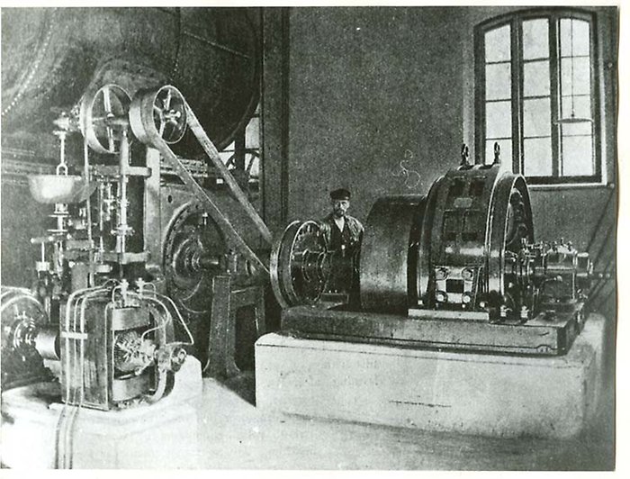 Interiör av Uddby kraftverk med maskinist. Foto från 1900-talets början.